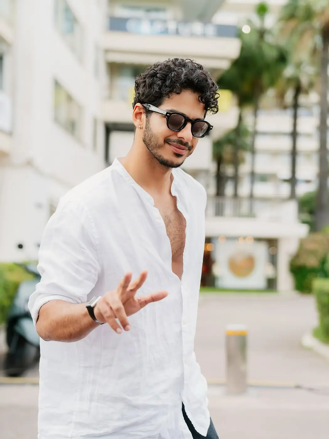 A guest in a white linen shirt flashing a peace sign