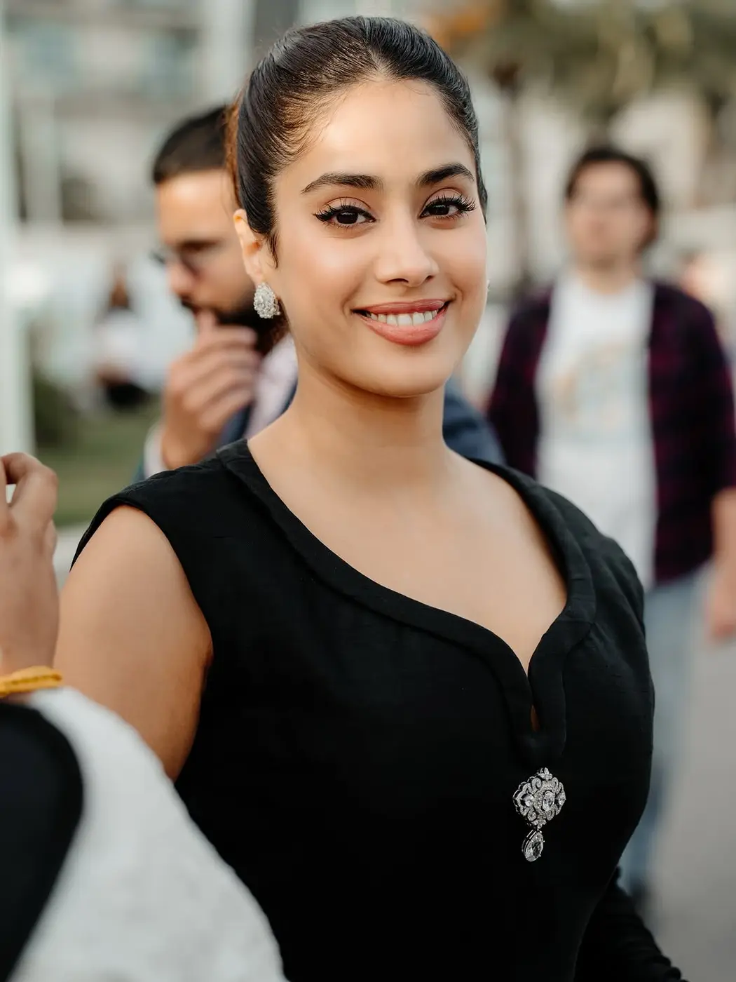 A smiling guest in a black dress among the crowd