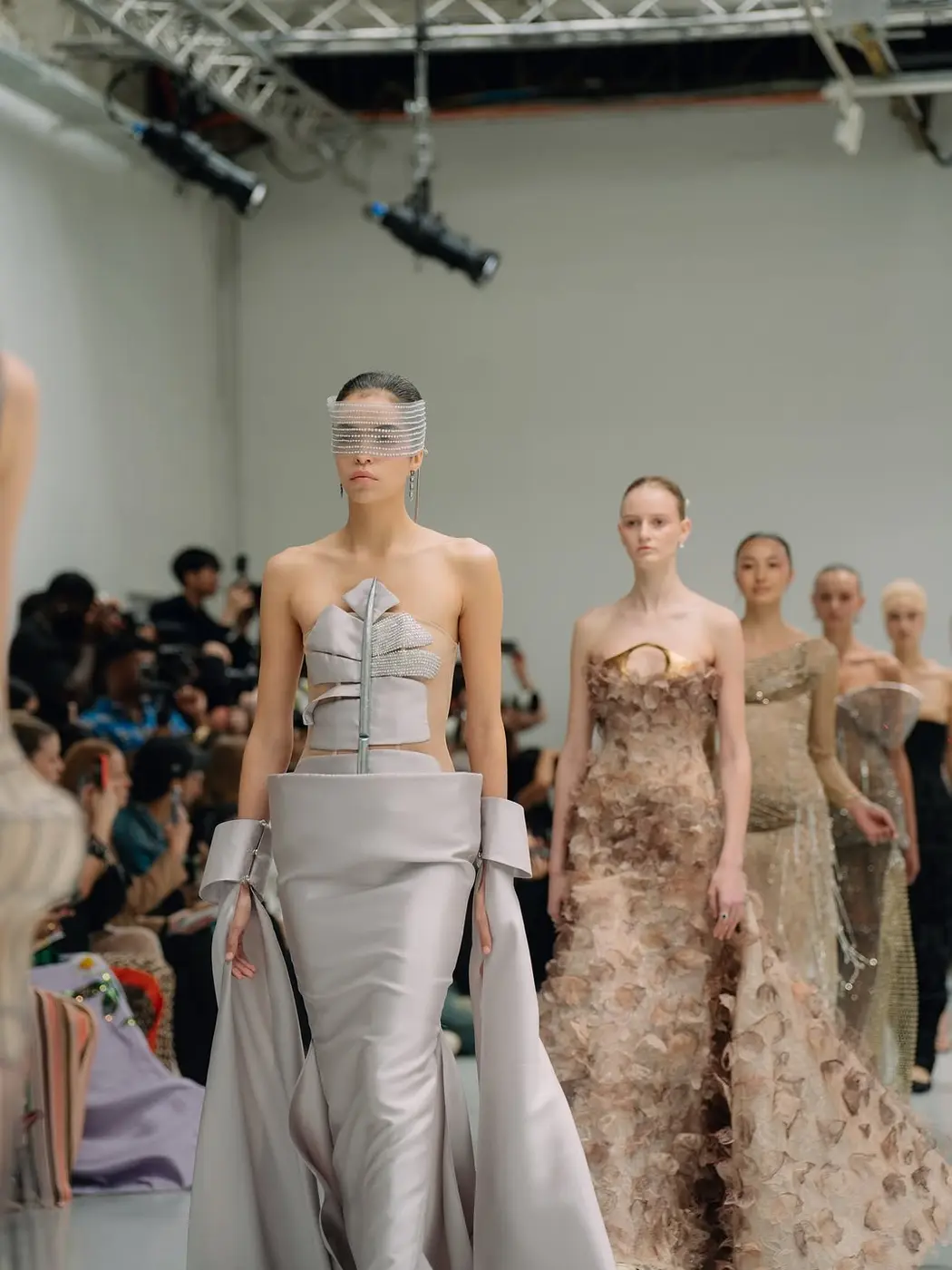 Models in silver and gold gowns on the runway