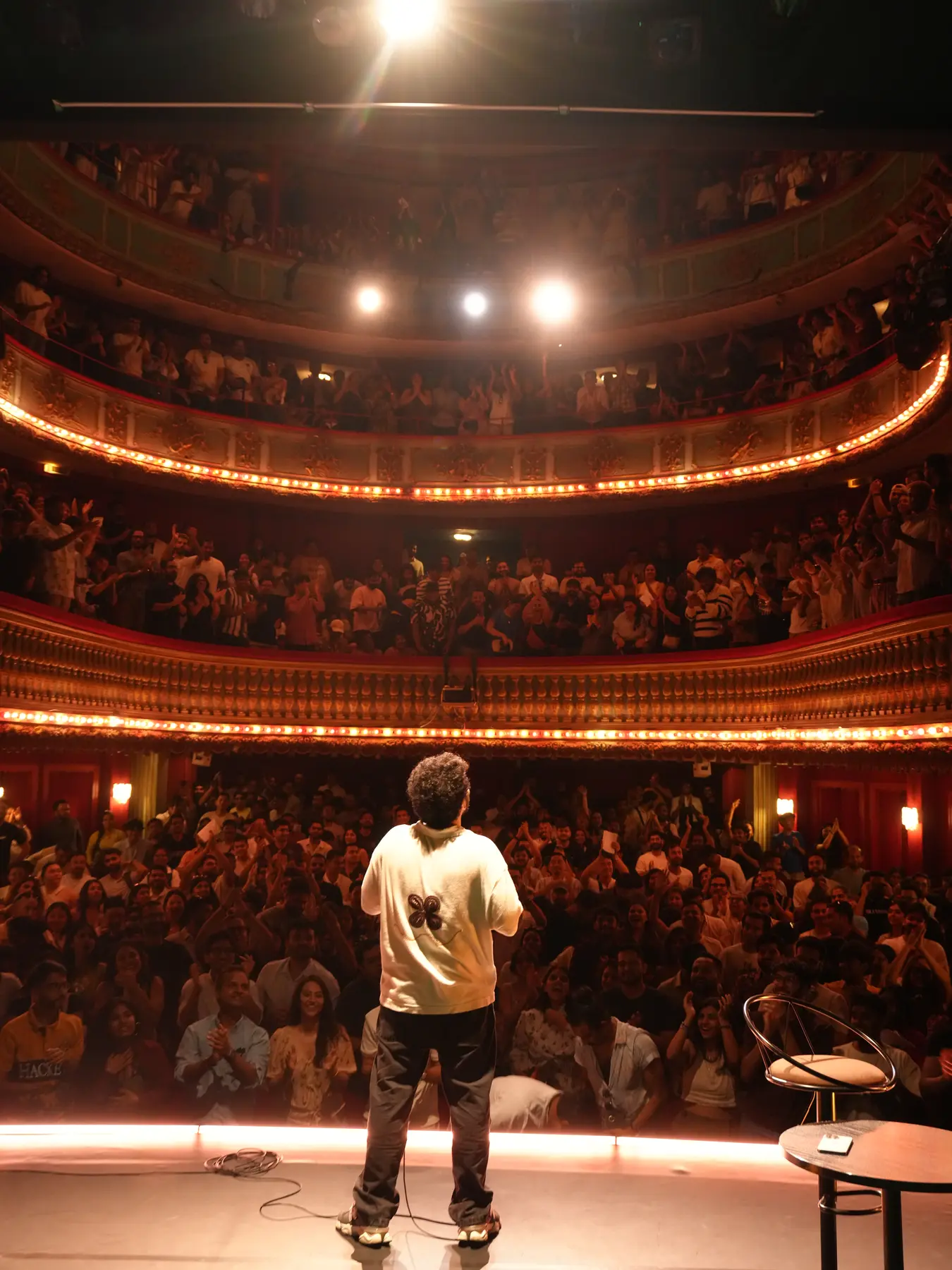 A full Paris theatre seen from the stage